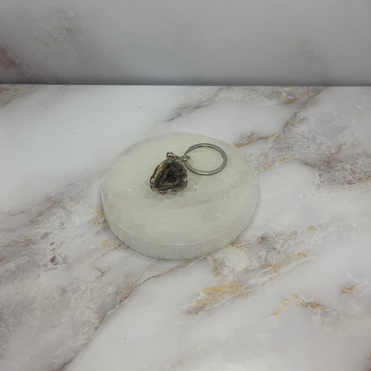 sleutelhanger 🪷 Agaat Druse – Uniek Kristal met Fonkelende Binnenzijde
Laat je betoveren door de natuurlijke schoonheid van onze agaat druse, een uniek stuk edelsteen dat de rustgevende energie van agaat combineert met de fonkelende magie van kleine kristalpunten aan de binnenzijde. Deze steen is perfect voor wie houdt van pure esthetiek én een energetische boost.

De agaat druse is niet alleen een prachtig decoratief object, maar wordt ook gewaardeerd om zijn aardende en beschermende werking. De schittere